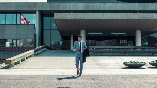 man walking while holding black coat