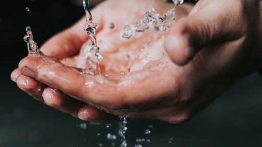 clear liquid pouring on person's hands